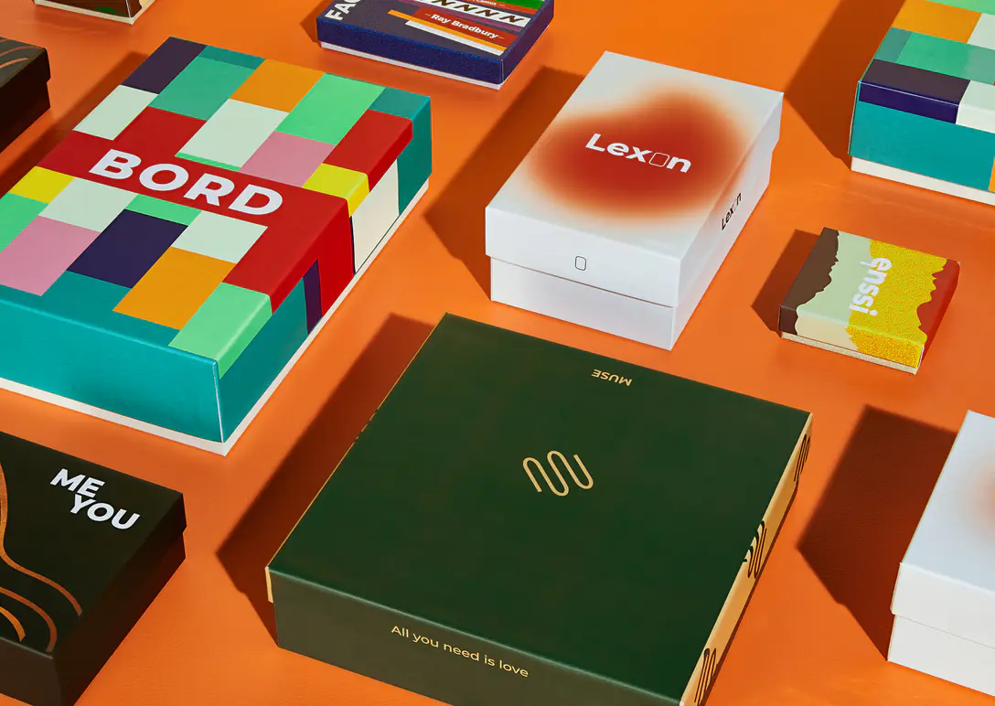 Custom rigid boxes with different printed finishes on an orange background