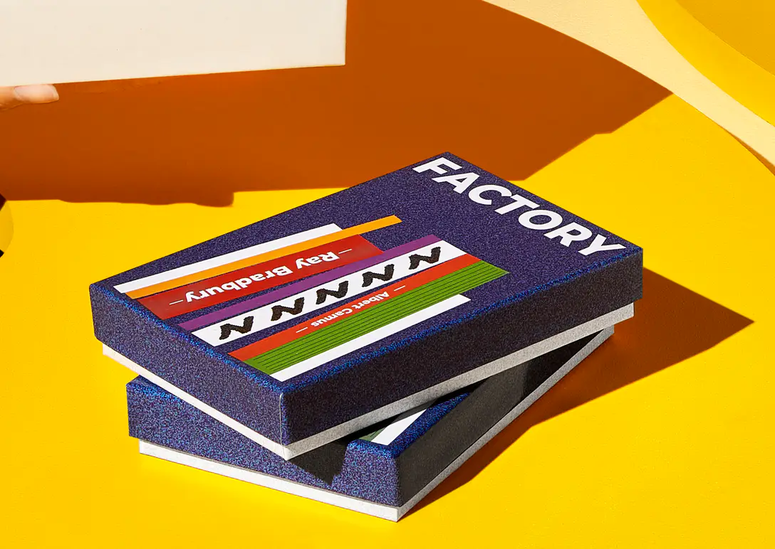 Two custom rigid boxes printed with the word Factory, stacked on a yellow surface